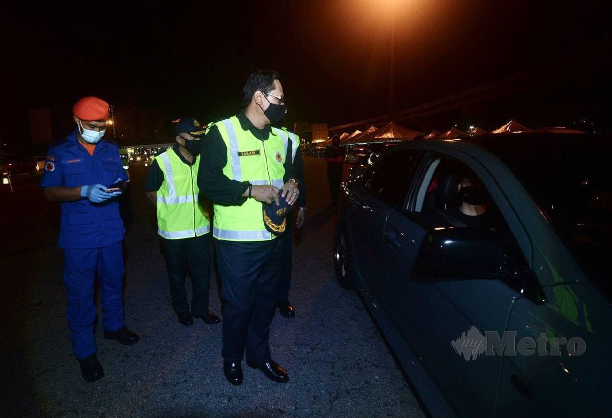 DATUK Zailani Hashim (tengah) turut sama membuat pemeriksaan kenderaan pada operasi Ambang Tahun Baru 2021 di Plaza Tol Sungai Besi menghala masuk ke pusat bandar. FOTO Khairul Azhar Ahmad