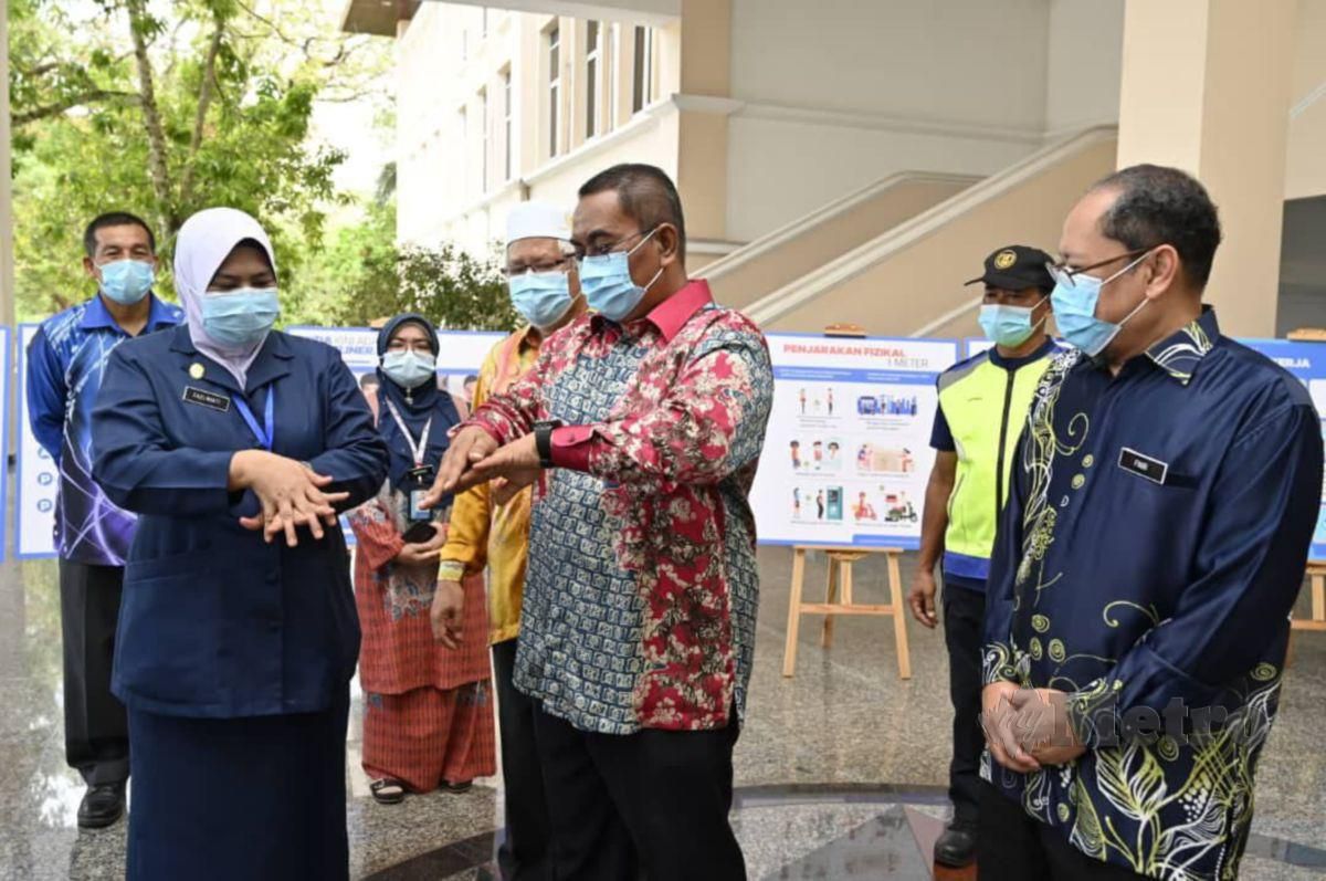 MUHAMMAD Sanusi Md Nor (dua kanan) meyerahkan mok cek kepada Mahamad Suhaimi Man sempena Kempen Pembudayaan Norma Baharu Peringkat Negeri Kedah di Wisma Darul Aman, di sini, hari ini. FOTO Noorazura Abdul Rahman