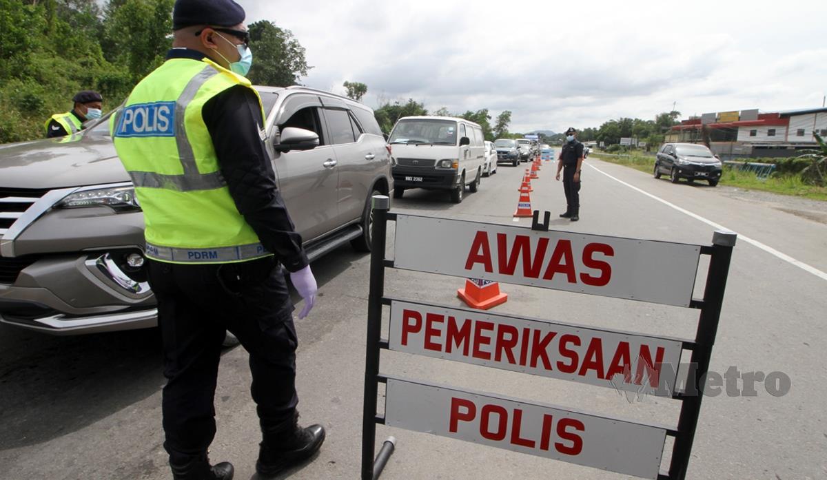 ANGGOTA PDRM melakukan SJR di Jalan Penampang-Papar Lama, pada hari pertama pelaksanaan PKP 2.0 di Sabah bagi membendung penularan COVID-19 di negeri ini. FOTO Malai Rosmah Tuah