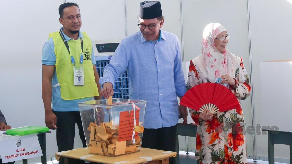 Datuk Seri Anwar Ibrahim (tengah) dan isteri Datuk Seri Dr Wan Azizah Wan Ismail (kanan) mengundi di Sekolah Kebangsaan (SK) Seri Penanti, Kubang Semang di sini, sempena Pilihan Raya Negeri (PRN) bagi kerusi Dewan Undangan Negeri (DUN) N11 Permatang Pasir. FOTO DANIAL SAAD
