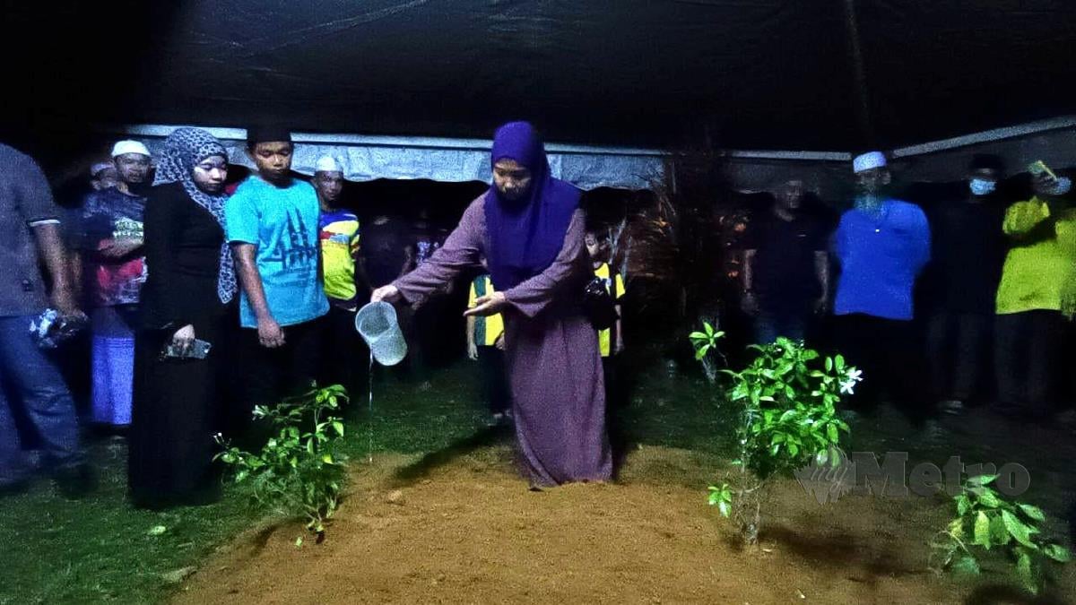 Nurain Hasnorizal menyiram air mawar di pusara anaknya, Muhammad Luth Syauqi yang meninggal dunia hari ini  akibat termakan keropok beracun. FOTO ZULIATY ZULKIFFLI