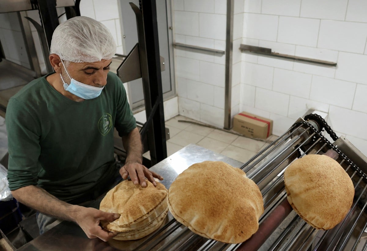 Seorang pekerja membungkus roti di kedai roti yang terletak di Beirut, Lubnan. - FOTO Reuters