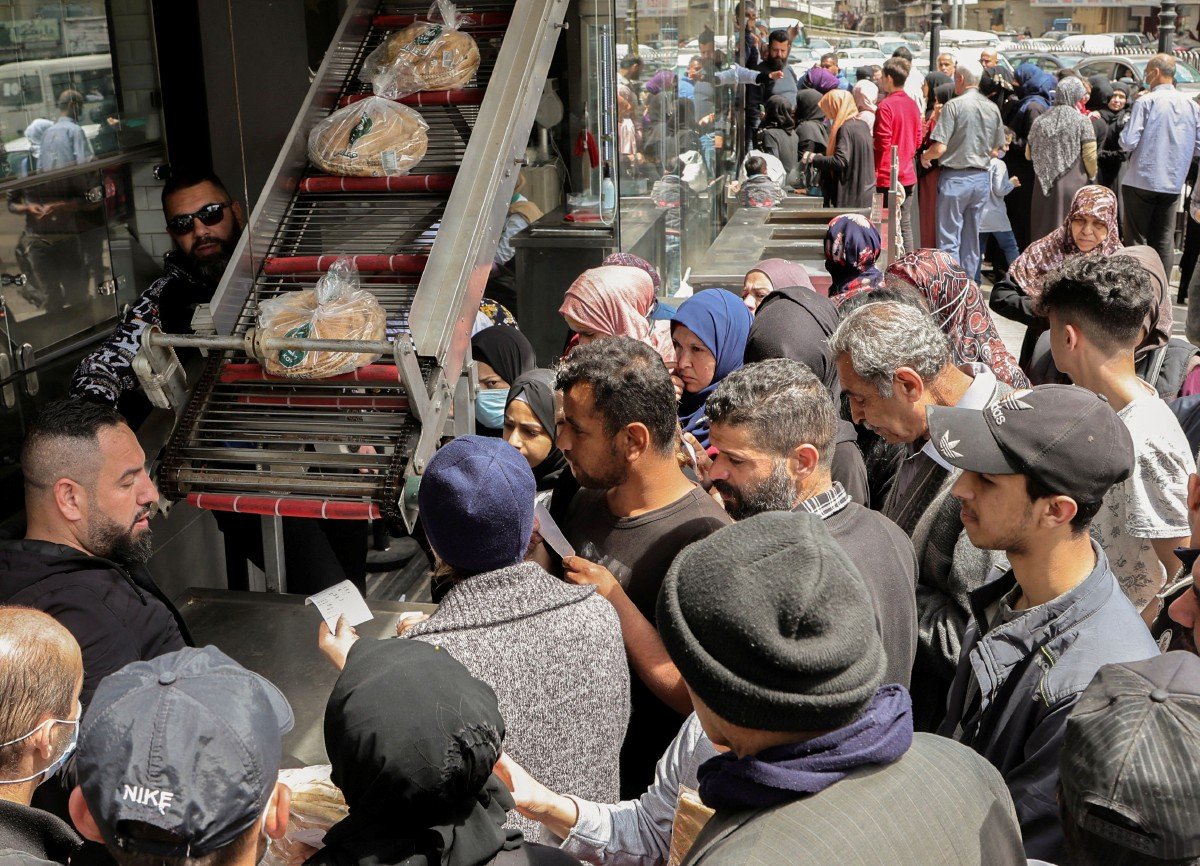 Orang ramai mendapatkan bekalan roti. - FOTO Reuters