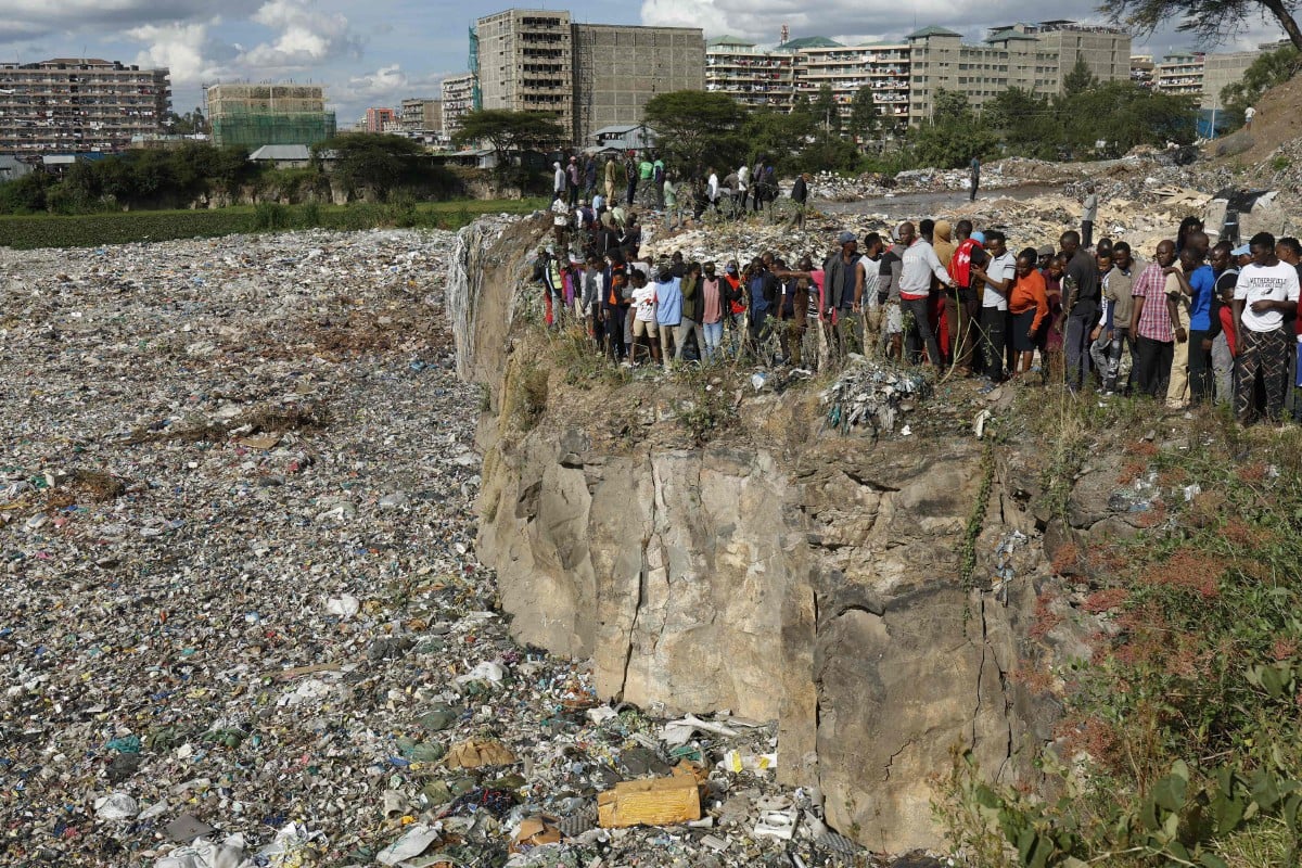 Orang ramai berdiri di tebing tapak pelupusan sampah selepas penemuan enam mayat wanita di Makuru, Nairobi. - FOTO AFP