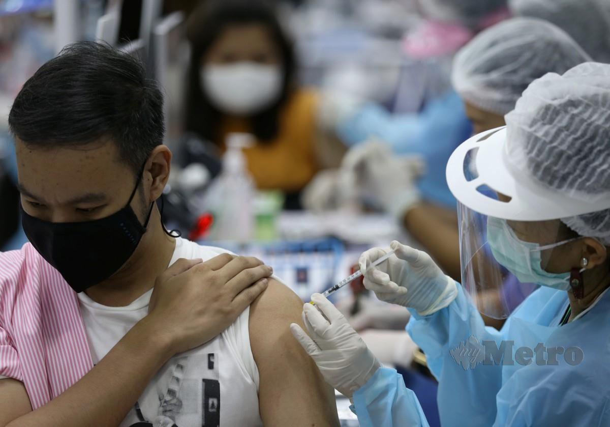 Seorang lelaki menerima suntikan vaksin AstraZeneca di Bang Sue Grand Station di Bangkok. - FOTO EPA