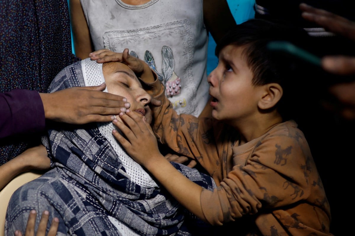 Seorang kanak-kanak menangis di sisi wanita selepas serangan Israel di hospital di Khan Younis. - FOTO Reuters