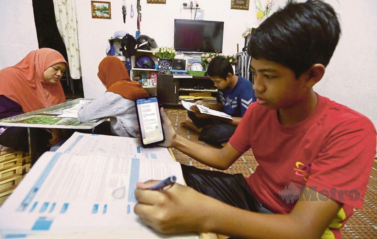 SITI Suriani mengajar anak perempuannya mengaji ketika anak lelakinya, menggunakan telefon bimbit untuk Pengajaran dan Pembelajaran di Rumah (PdPR).