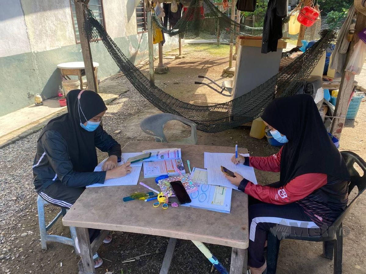 NUR Alea (kiri) dan Hanis Syuhada Razali (kanan) masing-masing berusia 16 tahun yang menetap di Pulau Aman terpaksa keluar belajar di luar rumah. FOTO Nur Izzati Mohamad