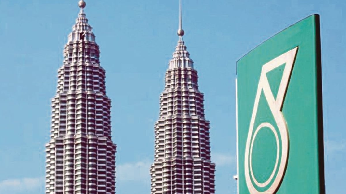 MENARA berkembar Petronas dilihat di belakang logo korporat syarikat di pusat bandar Kuala Lumpur. FOTO AFP