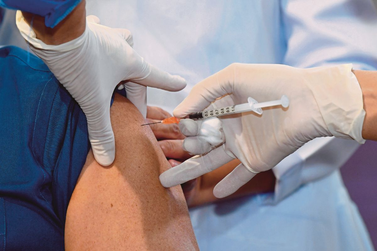 TAN Sri Muhyiddin Yassin menjadi individu pertama di negara ini menerima vaksin COVID-19 jenis Pfizer-BioNTech pada Program Imunisasi COVID-19 Kebangsaan di Pusat Kesihatan Daerah Putrajaya hari ini. FOTO  Bernama