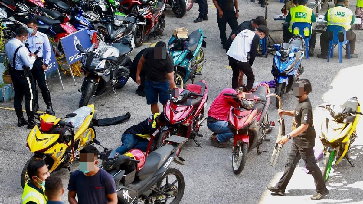 PENUNGGANG motorsikal menukar ekzos asal setelah ditahan dalam satu operasi, Khas Bunyi Bising bersama Jabatan Alam Sekitar di Jabatan Siasatan dan Penguatkuasaan Trafik Kuala Lumpur. FOTO Fathil Asri