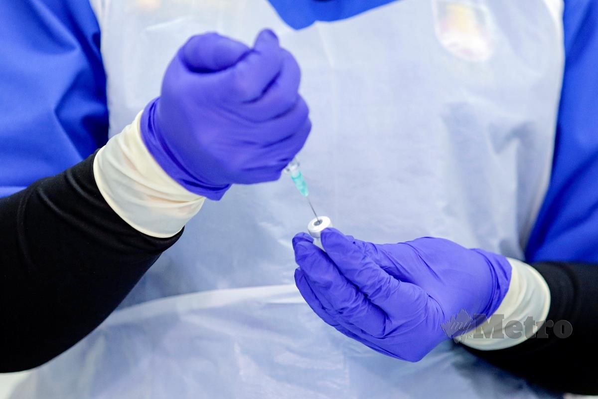 PETUGAS kesihatan mengambil cecair vaksin Pfizer BioNtech untuk suntikan pada seorang kakitangan hospital ketika tinjauan suntikan vaksin Covid-19 di Hospital UiTM, Sungai Buloh.  FOTO Aizuddin Saad