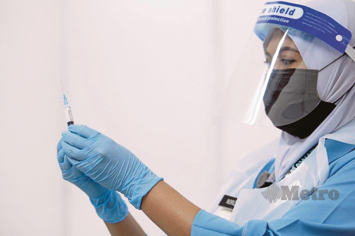 SEORANG petugas kesihatan mengambil dos suntikan vaksin Covid-19, Pfizer-BioNTech. FOTO Aizuddin Saad