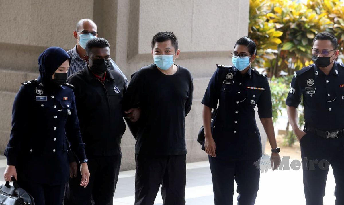 ANGGOTA polis mengiringi Tan Chee Keong, 44, ke mahkamah bagi menghadapi tuduhan penipuan pelaburan di Mahkamah Majistret Kuala Lumpur.  FOTO Hairul Anuar Rahim