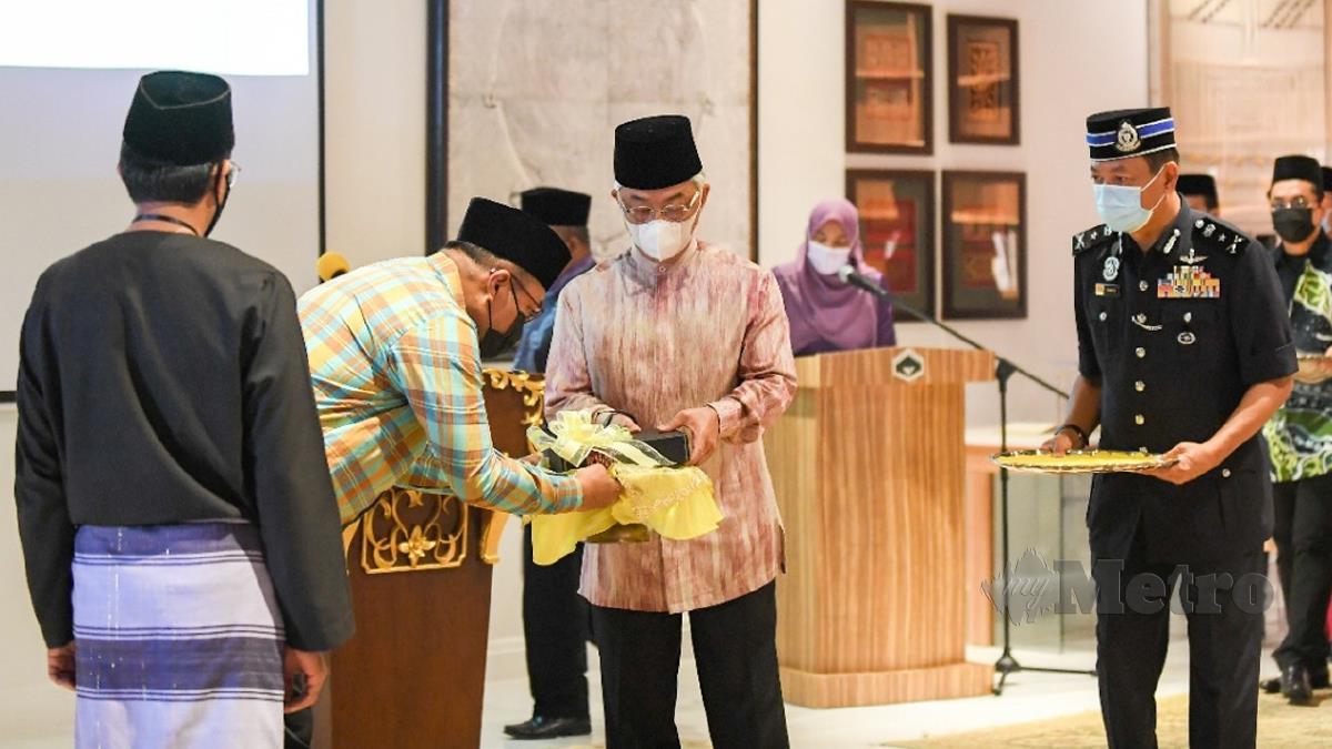 YANG di-Pertuan Agong, Al-Sultan Abdullah Ri'ayatuddin Al-Mustafa Billah Shah berkenan menerima cenderahati daripada Datuk Seri Mohd Sharkar Shamsudin. FOTO Shahrinnahar Latib