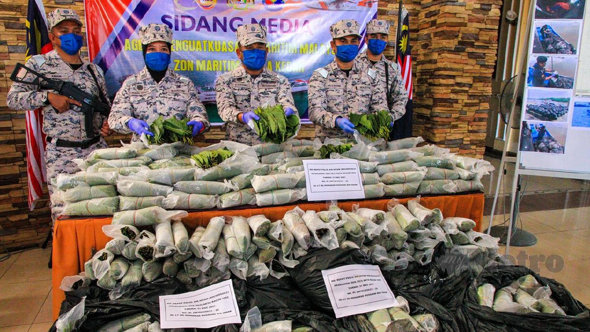 MOHD Zawawi Abdullah (tengah) menunjukkan sebahagian rampasan daun ketum dengan berat hampir satu tan berjumlah RM180,000 yang dirampas di perairan Kuala Jerlun. FOTO Luqman Hakim Zubir