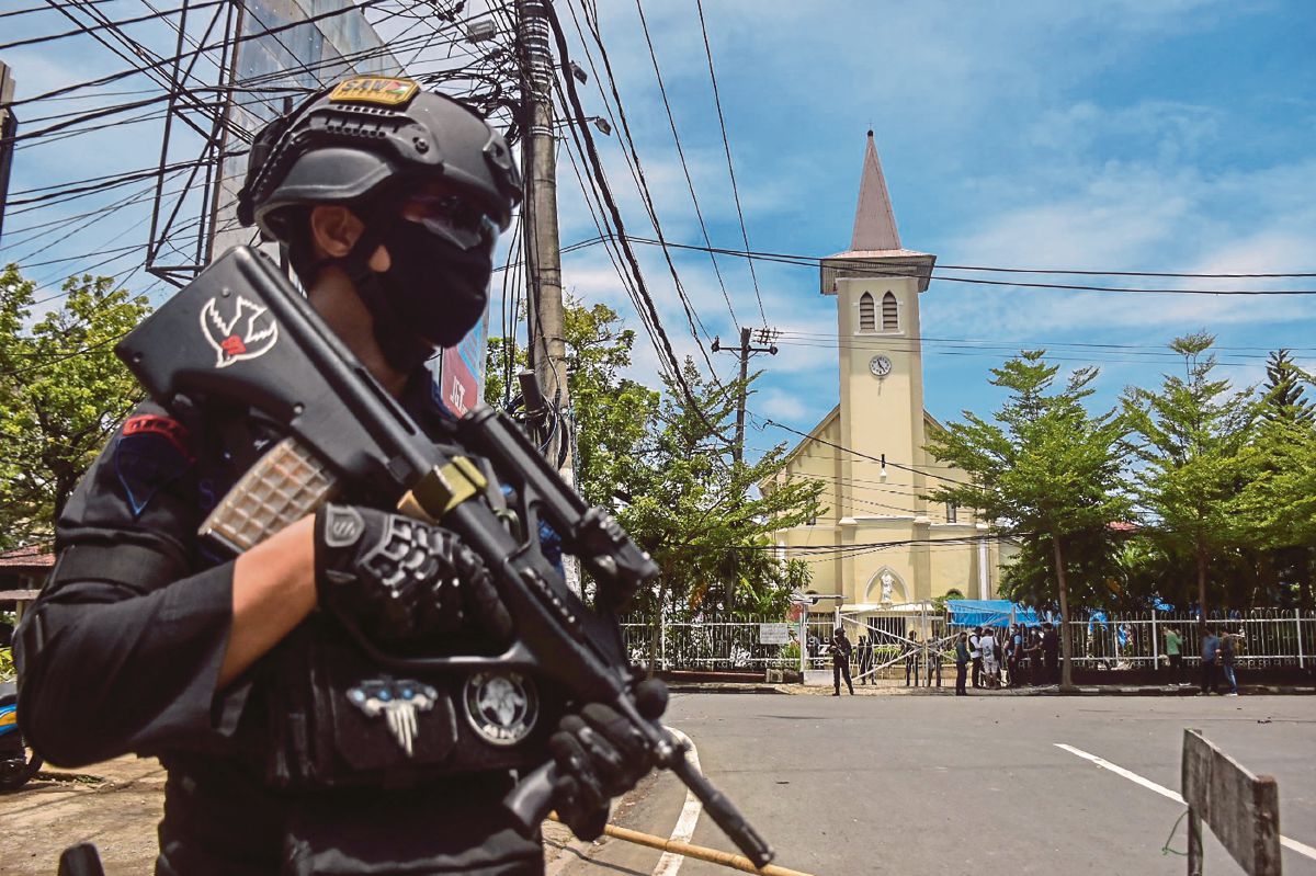 SEORANG polis Indonesia berjaga di luar sebuah gereja selepas letupan di Makassar. FOTO AFP