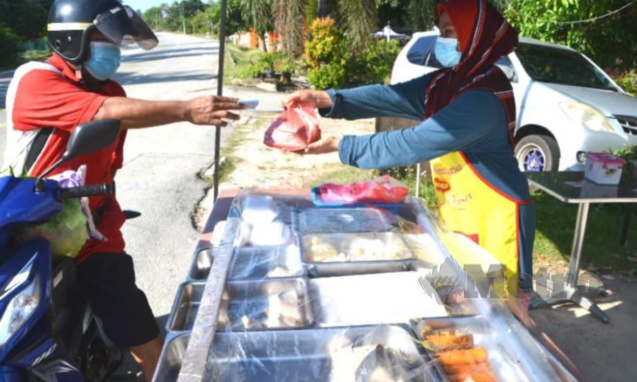 AZRIN hanya perlu membayar RM1 untuk setiap jenis makanan yang dibeli daripada Nazariyah Abustam di warung makan Alias Ahmad di Kampung Londang, Masjid Tanah. FOTO Hassan Omar
