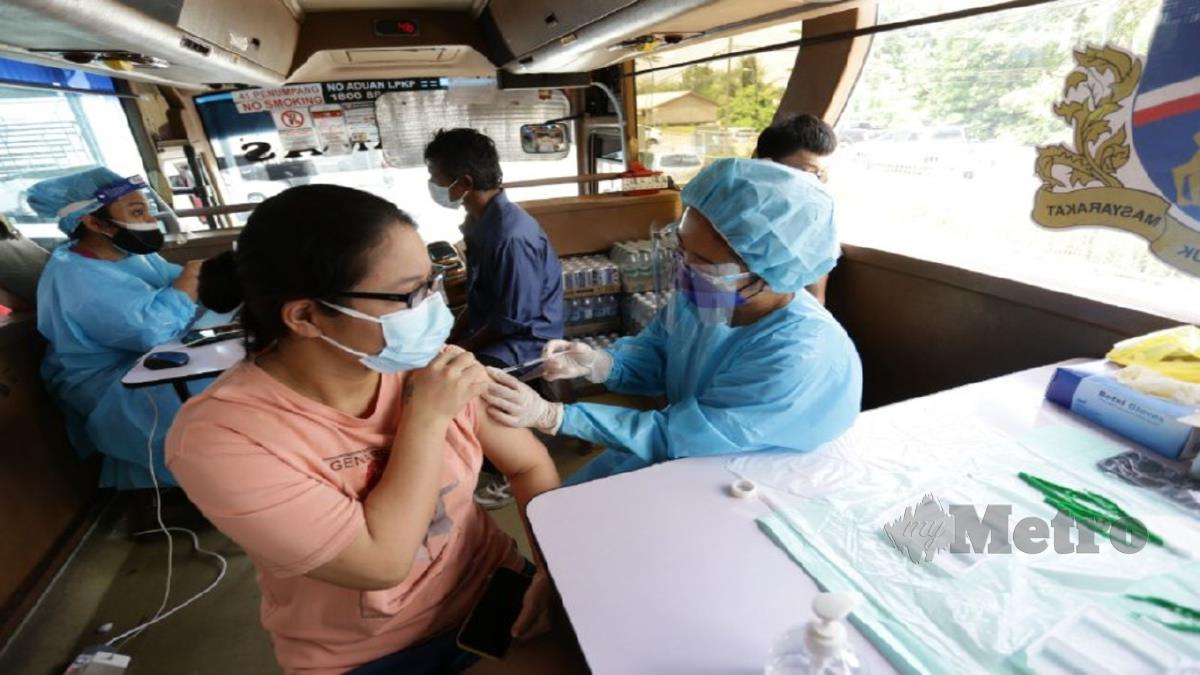PENDUDUK mendapatkan suntikan vaksinasi di dalam bas persiaran yang diubah suai anjuran Klinik Tanah Putih, JKKK Sungai Apong, MBKS Bus Asia, CLZ Care, di SJK (C) Sungai Apong, Kuching, Sarawak. FOTO NADIM BOKHARI