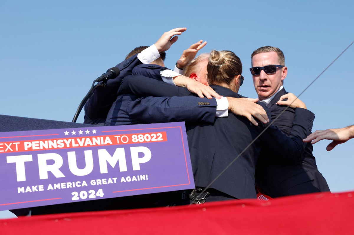 Trump dibawa turun dari pentas selepas insiden tembakan di Butler, Pennsylvania. - FOTO AFP