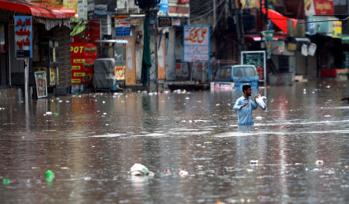 Seorang lelaki meredah banjir di Rawalpindi, Pakistan. - FOTO EPA