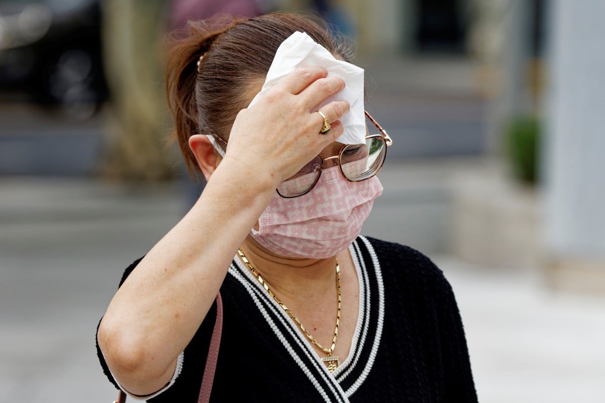 Seorang wanita mengelap peluh berikutan cuaca panas di Shanghai, China. - FOTO EPA