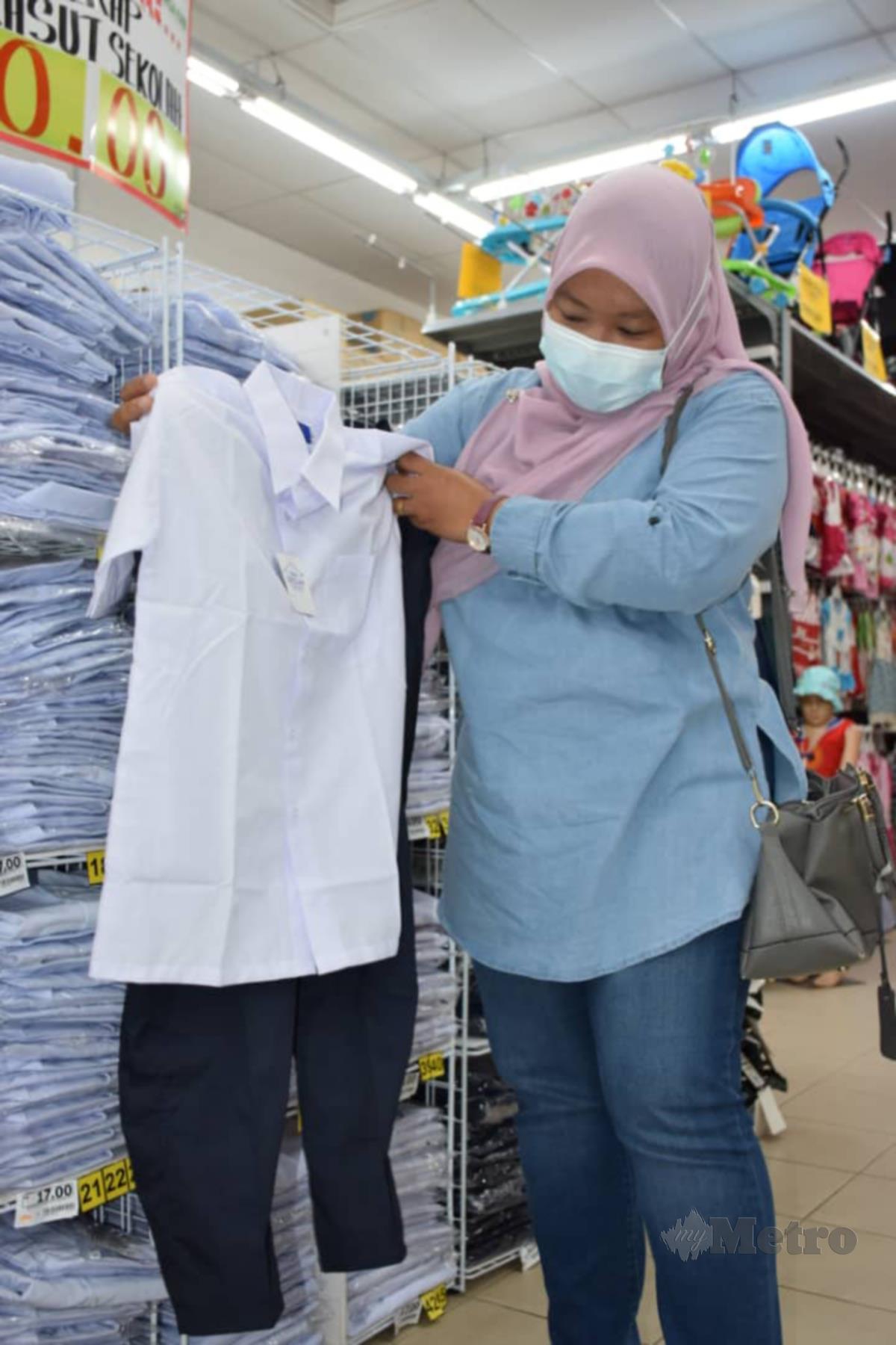 SITI Nor Faridah memilih baju sekolah untuk anaknya.