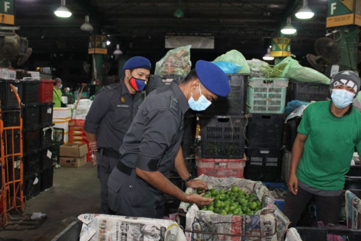 KETUA Pegawai Penguat Kuasa KPDNHEP Kuala Lumpur Zubir Hamsa melakukan pemeriksaan terhadap peniaga di Pasar Borong Kuala Lumpur, hari ini. FOTO ihsan KPDNHEP 