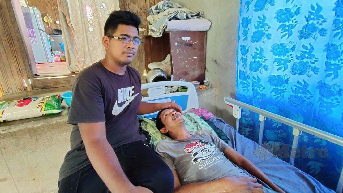 MOHAMAD Fitri sentiasa disamping abang tirinya, Julizahisham Mohamad, 36, yang lumpuh ketika ditemui di rumahny di Kampung Kampung Bukit Kechik, di sini, baru-baru ini. FOTO Syaherah Mustafa