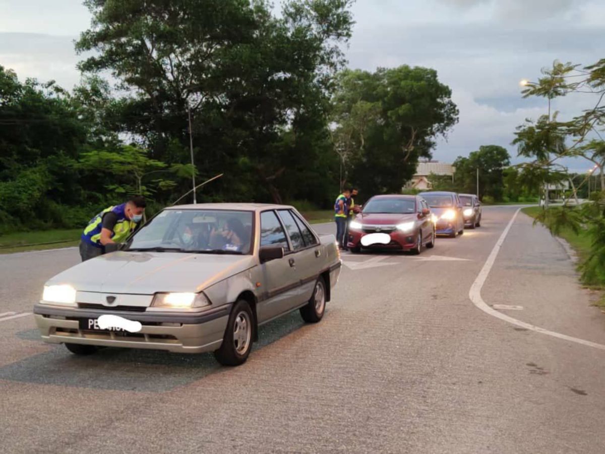 ANGGOTA polis melakukan pemeriksaan kenderaan di SJR bergerak berhampiran Jalan Muzium Padi dan dua individu ditahan kerana merentas daerah tanpa surat kebenaran polis. FOTO ihsan PDRM
