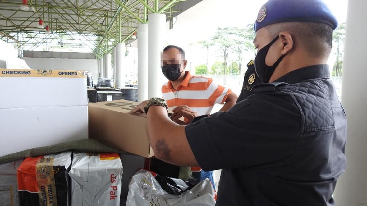 ANGGOTA penguat kuasa KPDNHEP Selangor dengan kerjasama JKDM merampas 76 kasut berjenama tiruan di Bay Pemeriksaan Rapi Penguatkuasaan Kastam, KLIA, hari ini. FOTO ihsan KPDNHEP SELANGOR
