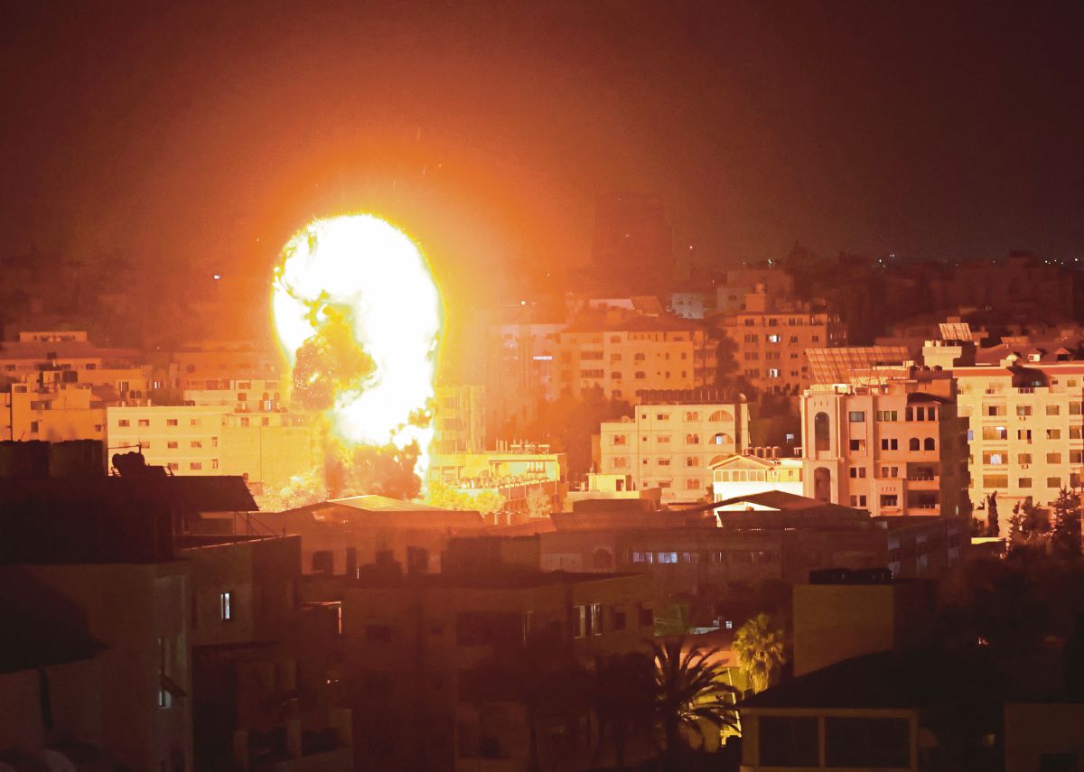 API marak dan asap di atas bangunan di Kota Gaza ketika pesawat perang Israel mensasarkan kawasan kantong, Palestin. FOTO AFP