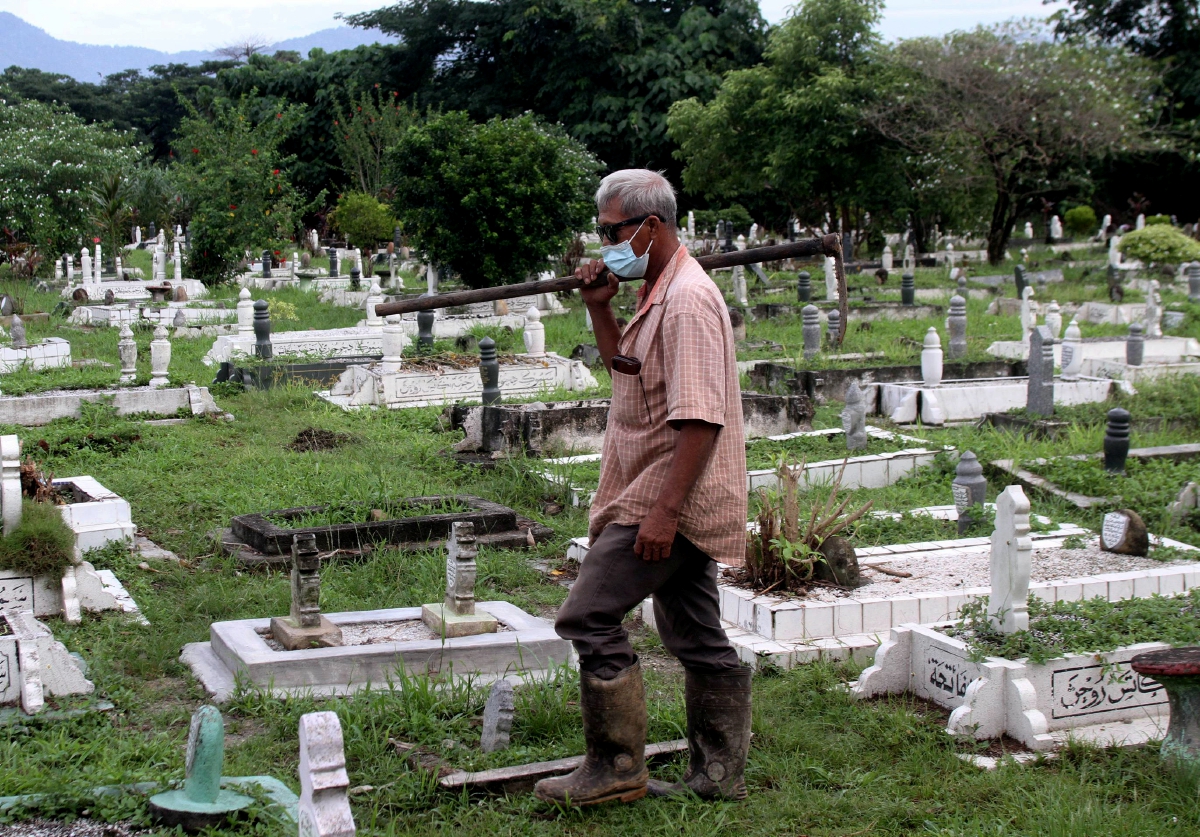 SHUIB Aziz yang terlibat menguruskan jenazah mangsa kes COVID-19 di Tanah Perkuburan Islam Jalan Bendahara membawa cangkul untuk menggali kubur mangsa yang meninggal dunia akibat wabak itu baru-baru ini. FOTO Bernama
