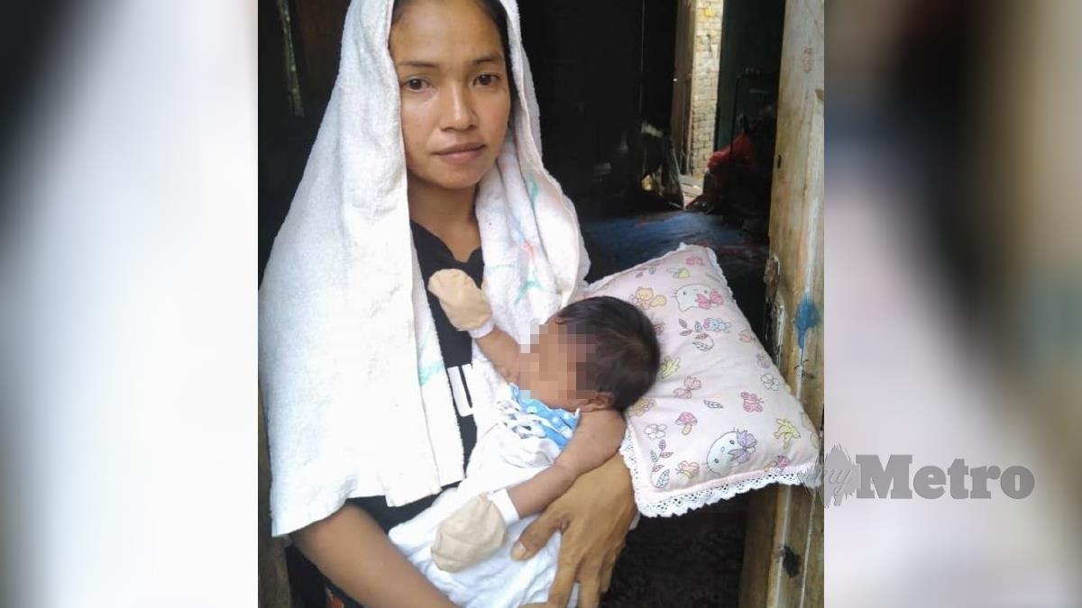 NURUL Wahida Kamarudin sambil mendukung anaknya, bayi jantung berlubang, NurulAishah di rumahnya di Felda Kota Gelanggi Dua. FOTO Roselan Ab Malek