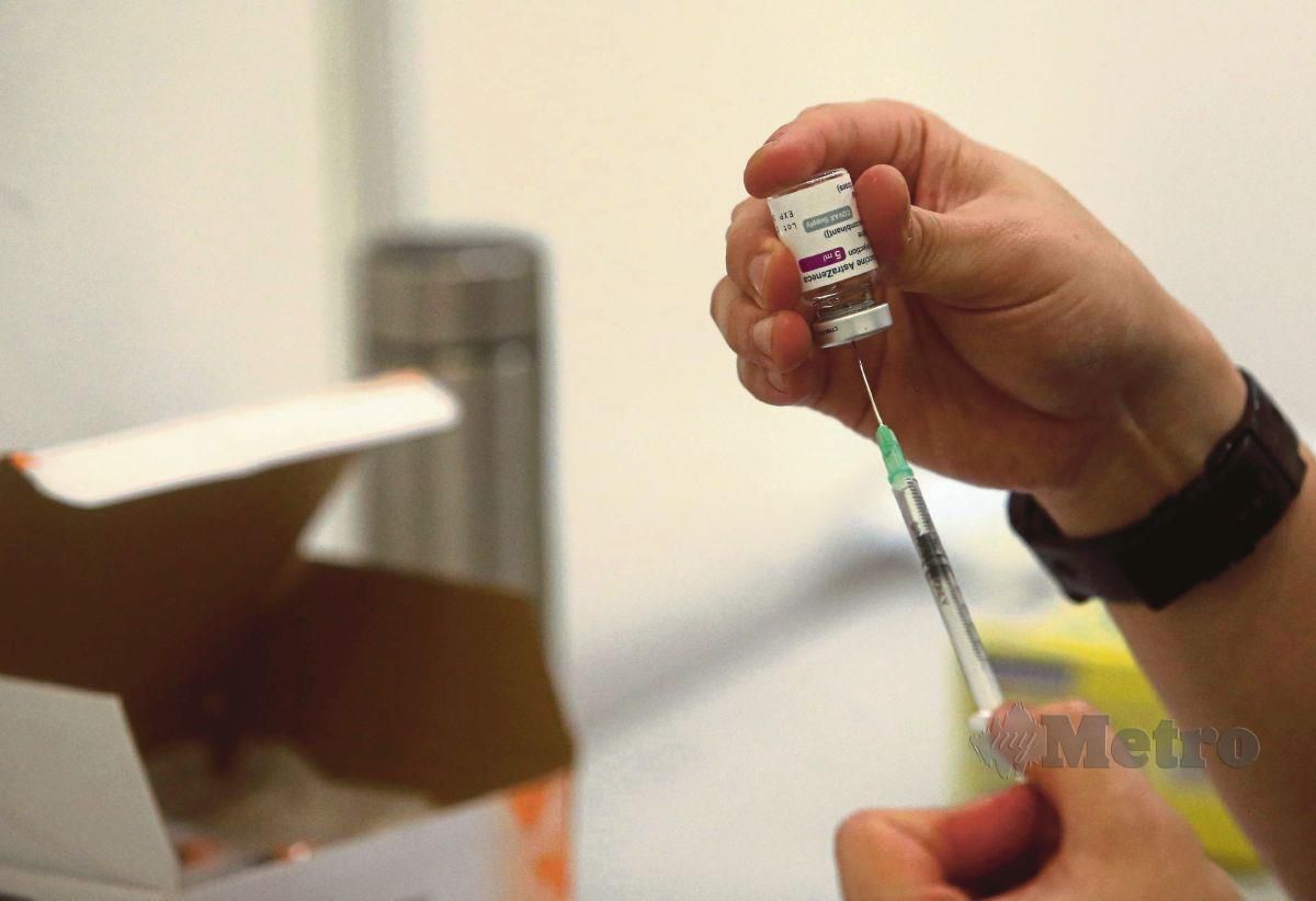 PETUGAS kesihatan memasukkan cecair vaksin COVID-19 AstraZaneca di Pusat Pemberian Vaksin (PPV). FOTO Muhd Asyraf Sawal