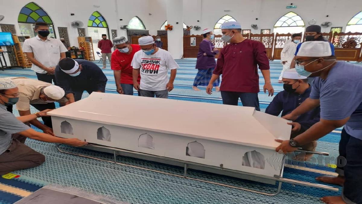 ADY Iskandar (tiga dari kanan) dan jemaah solat jenazah memasang penutup keranda selepas solat jenazah di Masjid Kampung Ramuan Cina Besar, Masjid Tanah. FOTO HASSAN OMAR