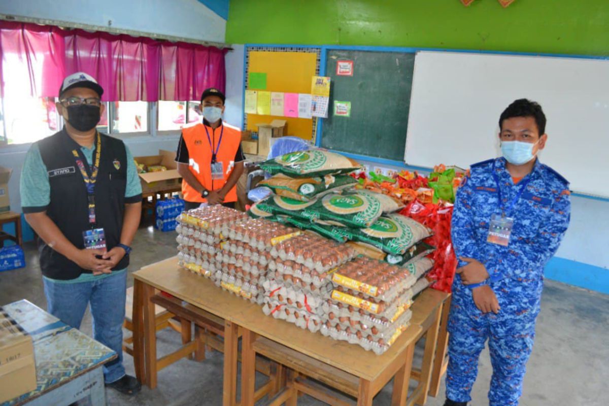 PETUGAS PKPD Mukim Juasseh menunjukkan sebahagian bekalan makanan kering yang dibekalkan kepada penduduk di kawasan itu. FOTO ihsan Petugas PKPD