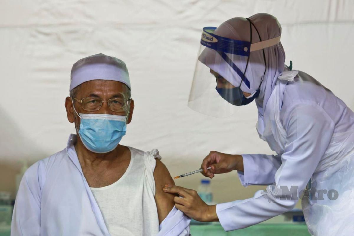 ABDUL Rahman Md Hassan menerima suntikan vaksin di Pusat Pemberian Vaksin (PPV), Stadium Tertutup Kompleks Sukan Gong Badak hari ini. FOTO Ghazali Kori