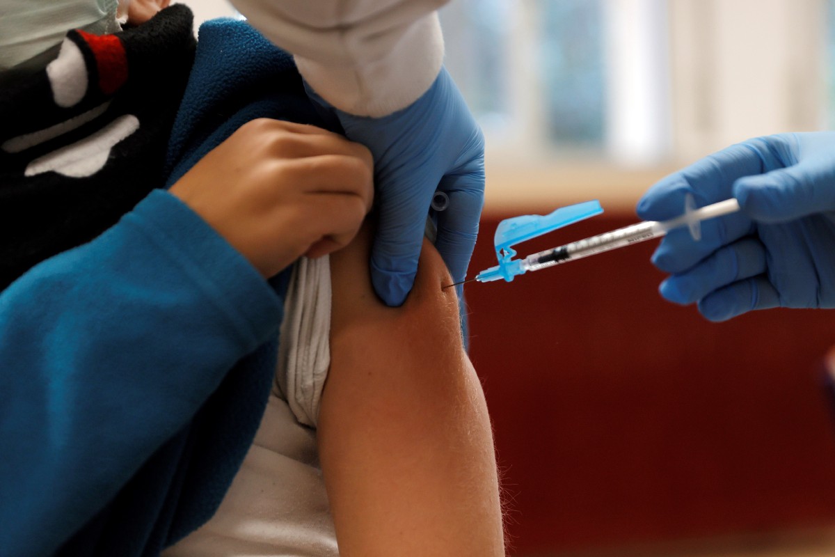 Seorang kanak-kanak menerima vaksin Covid-19 di sekolah di Valencia, Sepanyol. - FOTO EPA