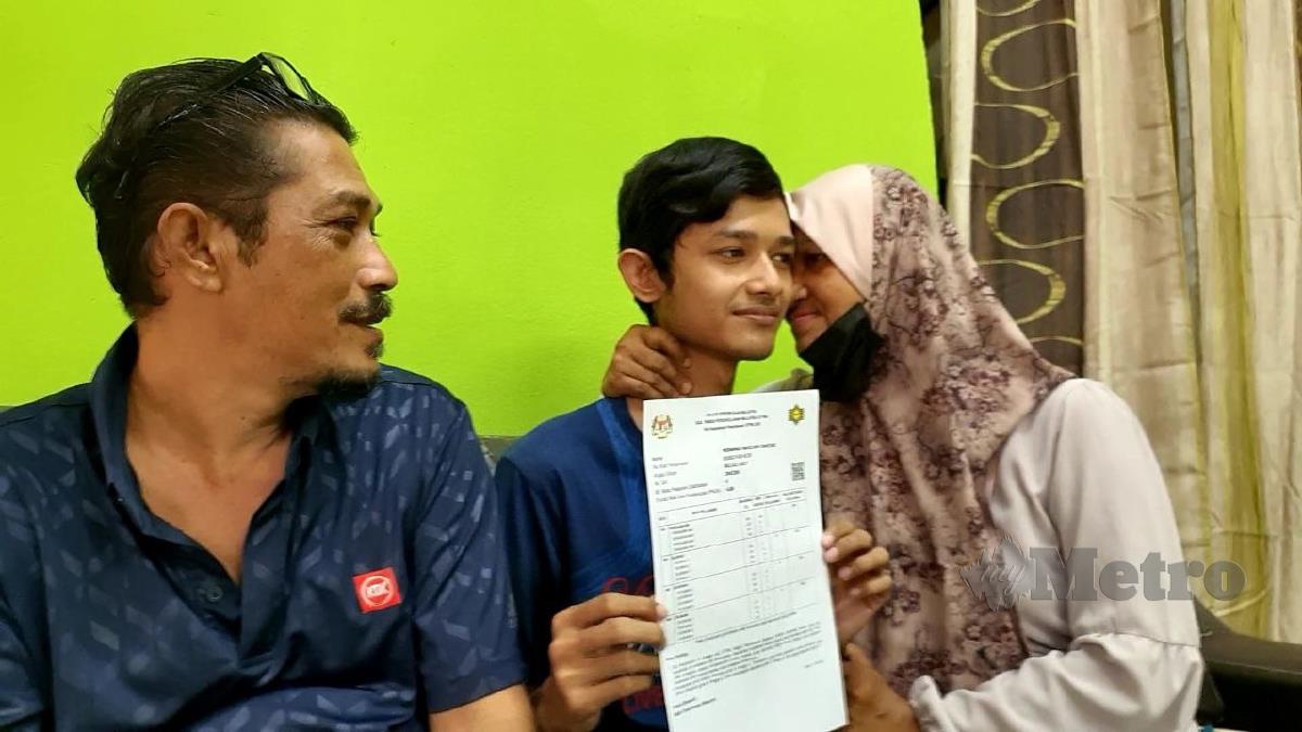 MOHAMAD Hafiz (tengah) menerima ciuman ibunya sambil diperhatikan bapanya selepas memperoleh PNGK 4.00 dalam STPM. FOTO Hamzah Osman