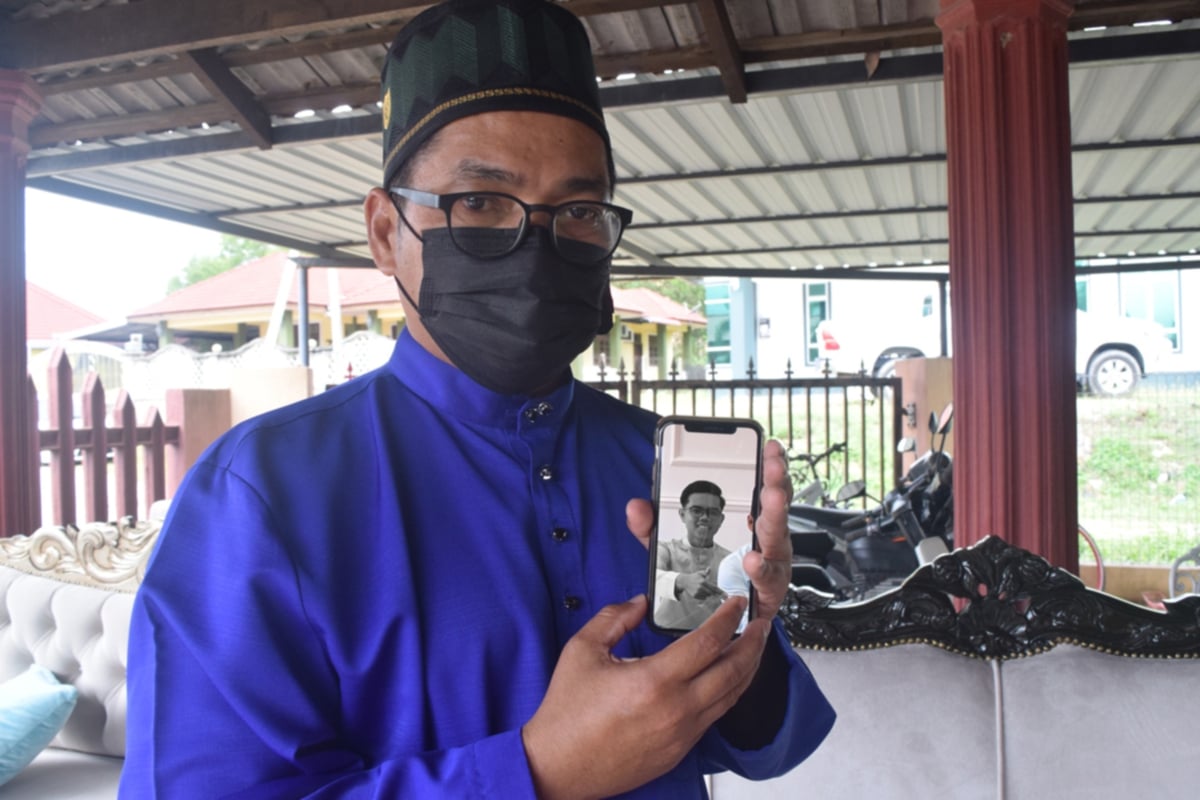 MOHD Rizaini menunjukkan gambar anaknya Muhammad Adham Hazim mahasiswa UiTM Jengka, Pahang yang meninggal dunia akibat pendarah dalam kepala. FOTO Bernama