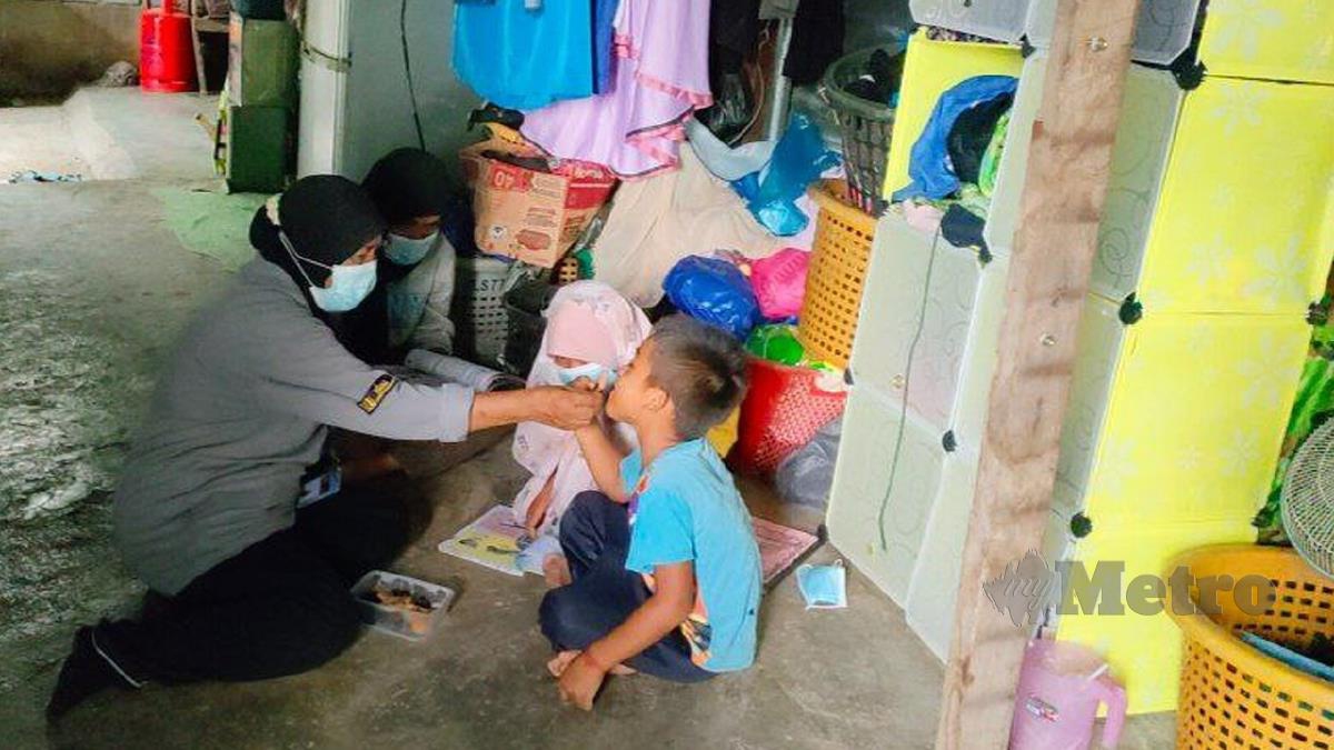 ZALEHA (kiri) menyuap makanan kepada cucunya, Muhamad Hakimi, 6, manakala dua cucunya sedang mengikuti kelas PdPR di rumah mereka di Kuala Kedah. FOTO Zuliaty Zulkiffli