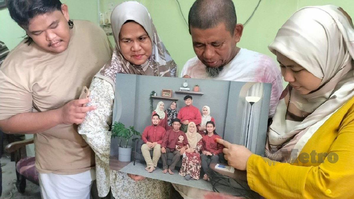 Muhamad Salleh (kanan) bersama isteri dan anaknya melihat gambar kenangan Allahyarham Muhammad Hafiz. FOTO Zuliaty Zulkiffli