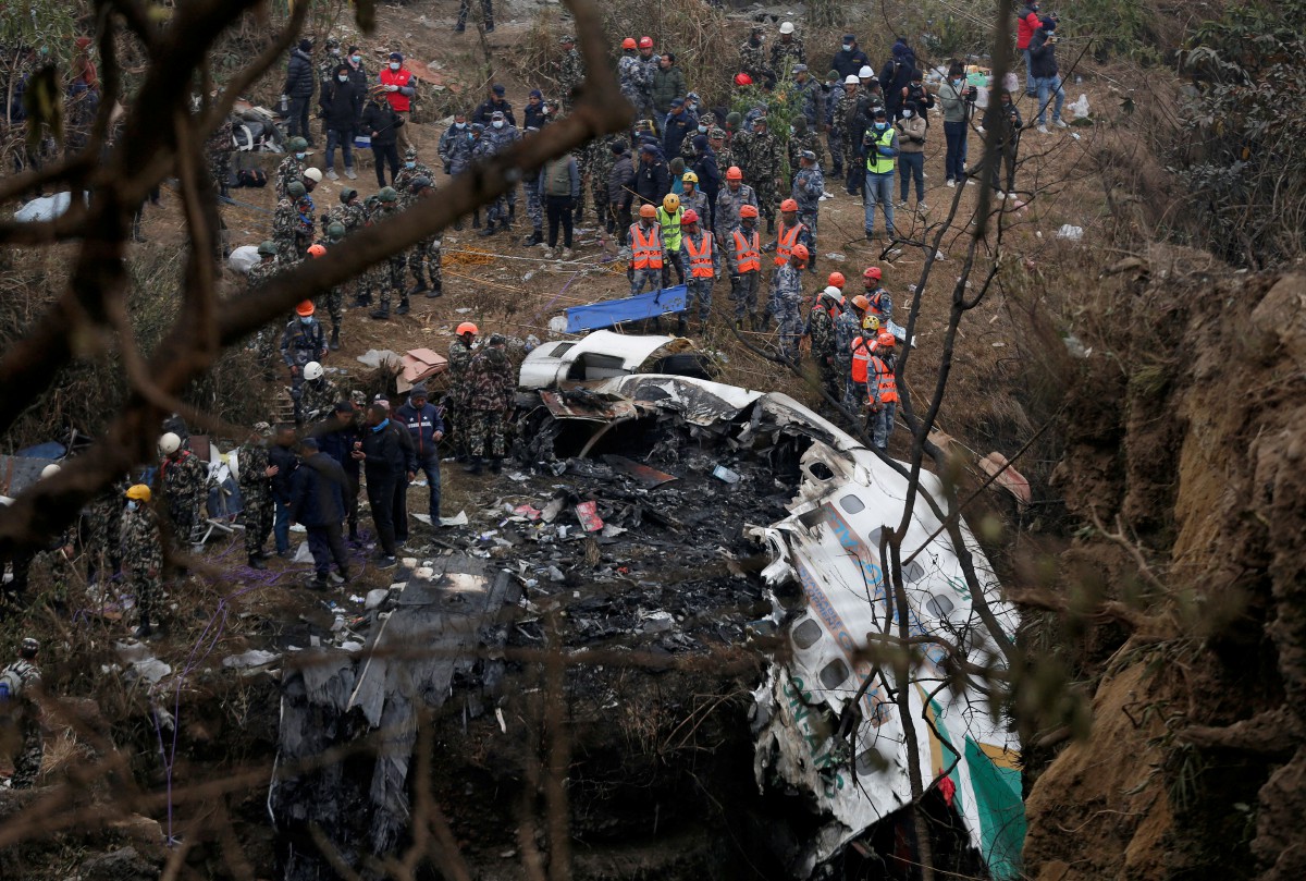Pasukan penyelamat membawa keluar mangsa dari pesawat Yeti Airlines yang terhempas. - FOTO Reuters