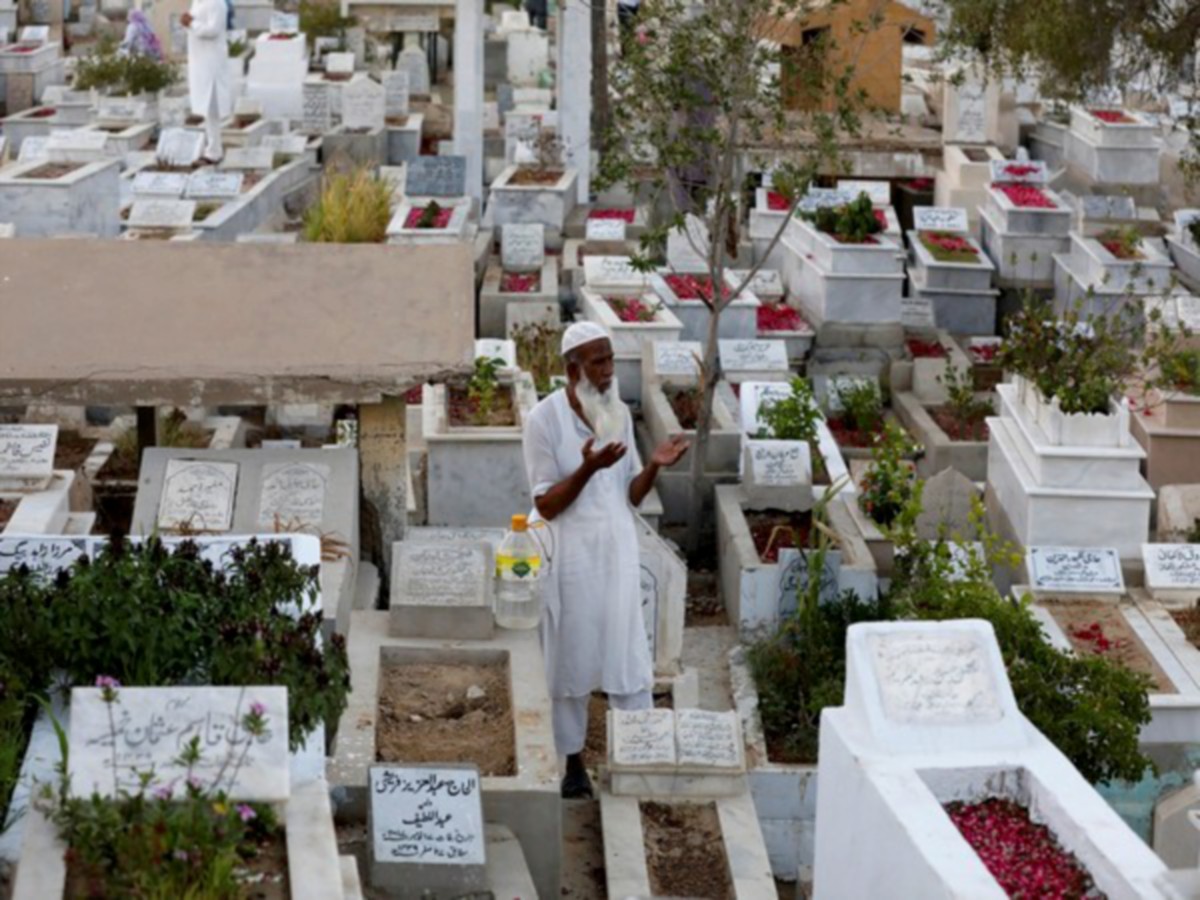 Seorang lelaki menziarah kubur di Karachi, Pakistan. - FOTO REUTERS 