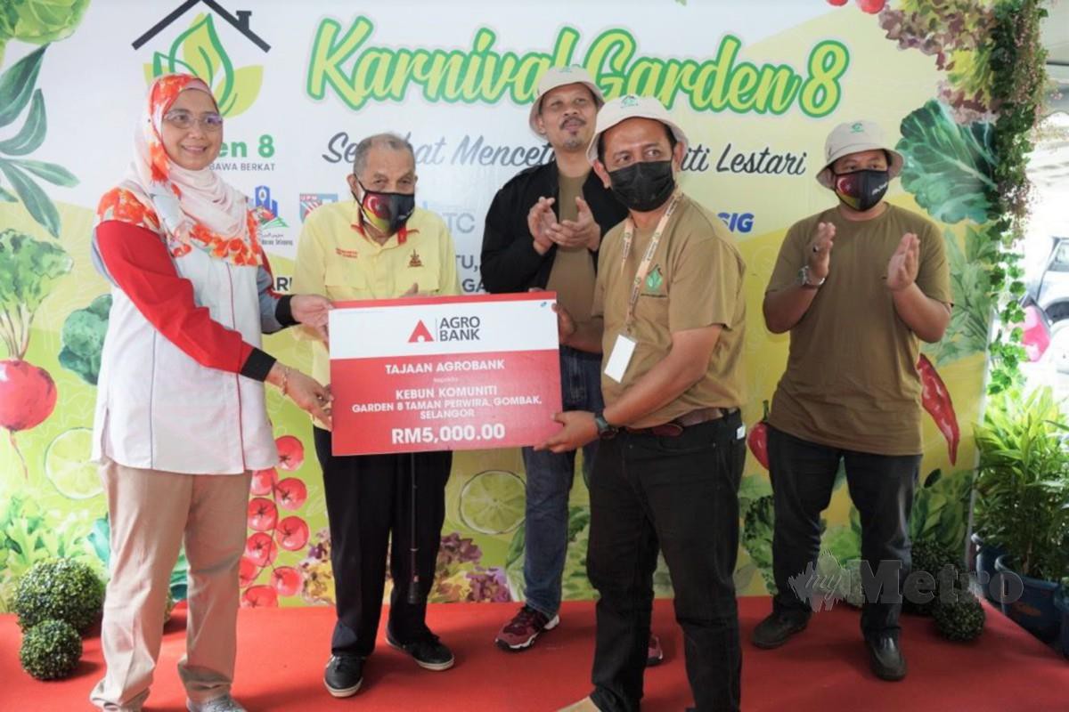 ZURINA (kiri) menyerahkan replika cek bernilai RM5,000 kepada wakil Komuniti Garden 8.