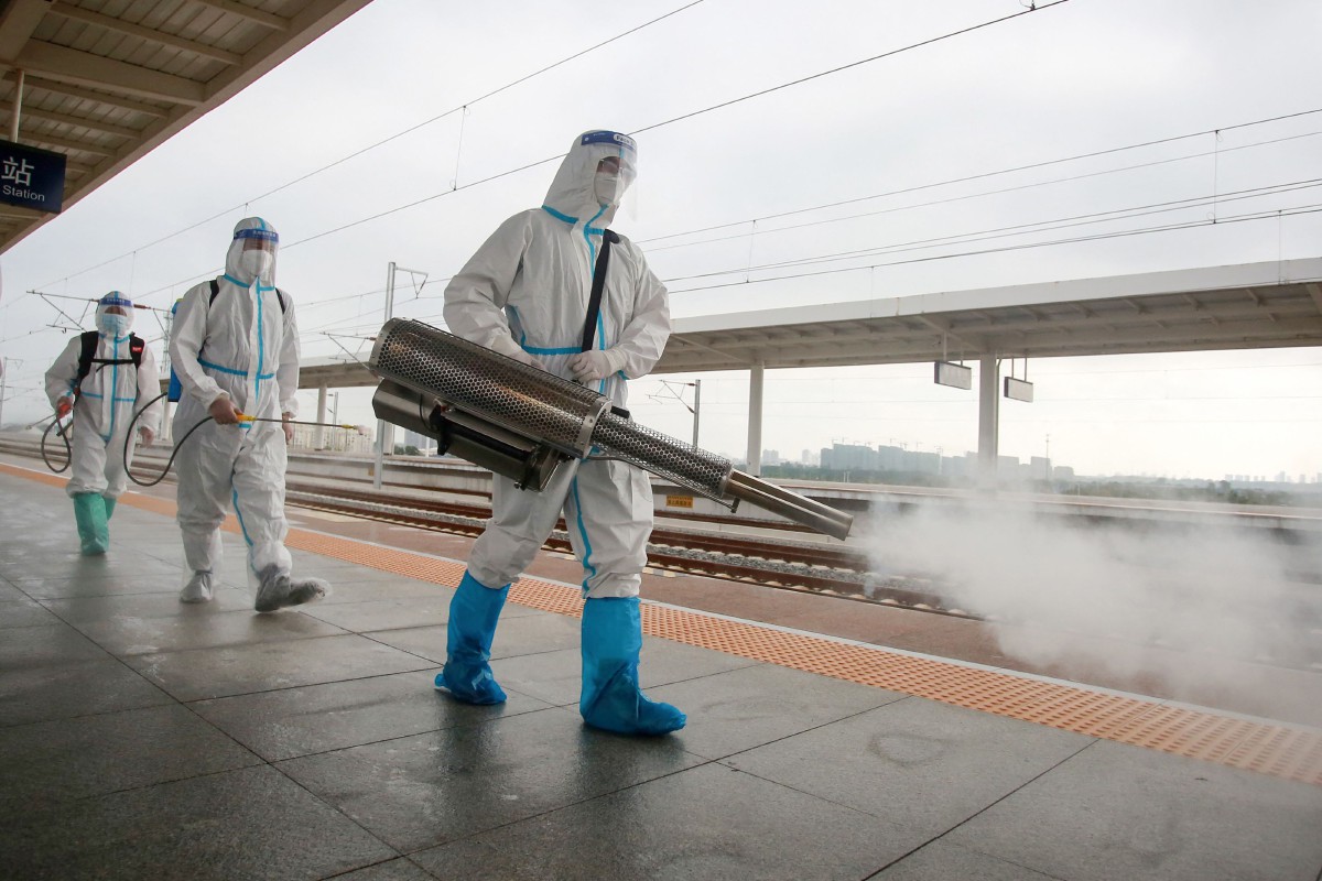 Anggota bomba menyembur cecair disinfektan di stesen kereta api Yangzhou di wilayah Jiangsu, China. - AFP