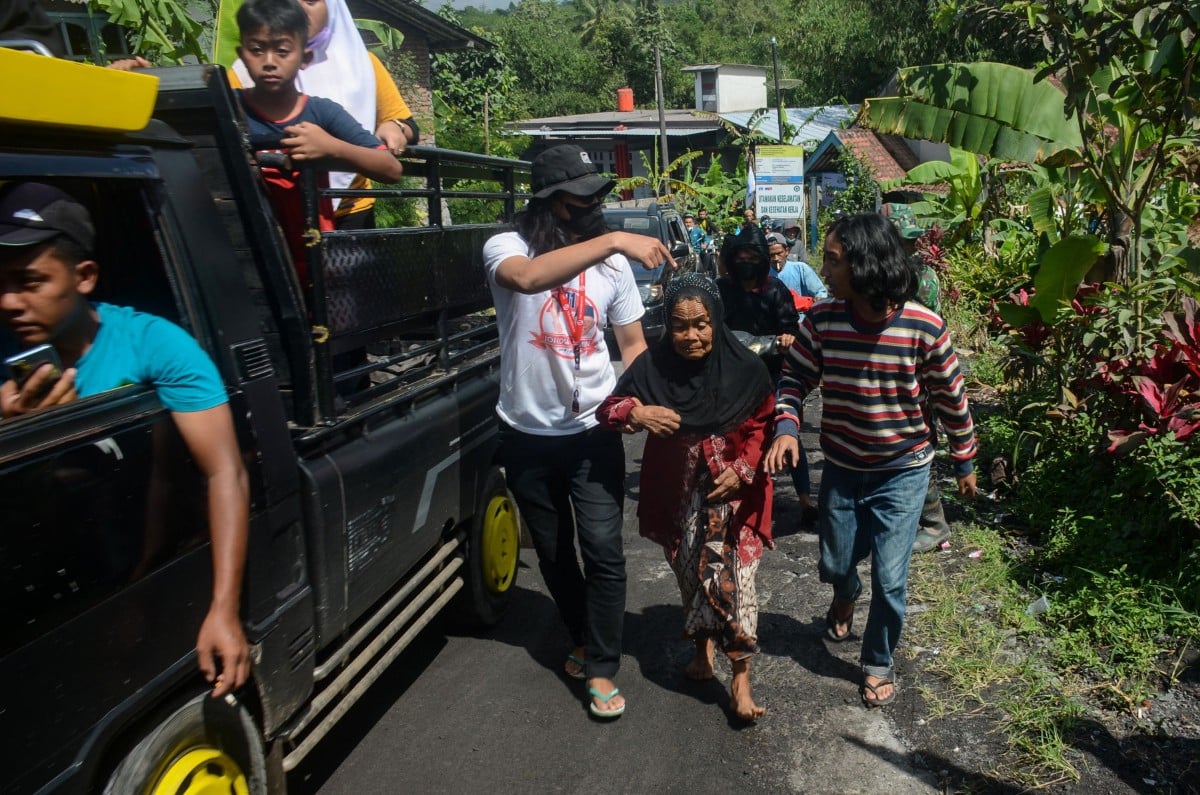 Penduduk kampung Supit Urang menyelamatkan diri selepas Gunung Semeru meletus lagi. - FOTO AFP