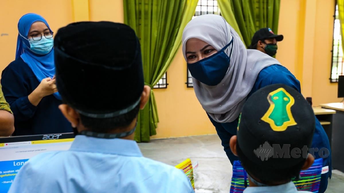 DATUK Seri Rina Mohd Harun bermesra dengan anak-anak ketika meninjau ketersedian RKK Pokok Sena untuk menerima kemasukan anak-anak yang kehilangan ibu bapa atau penjaga akibat pandemik Covid. FOTO Luqman Hakim Zubir