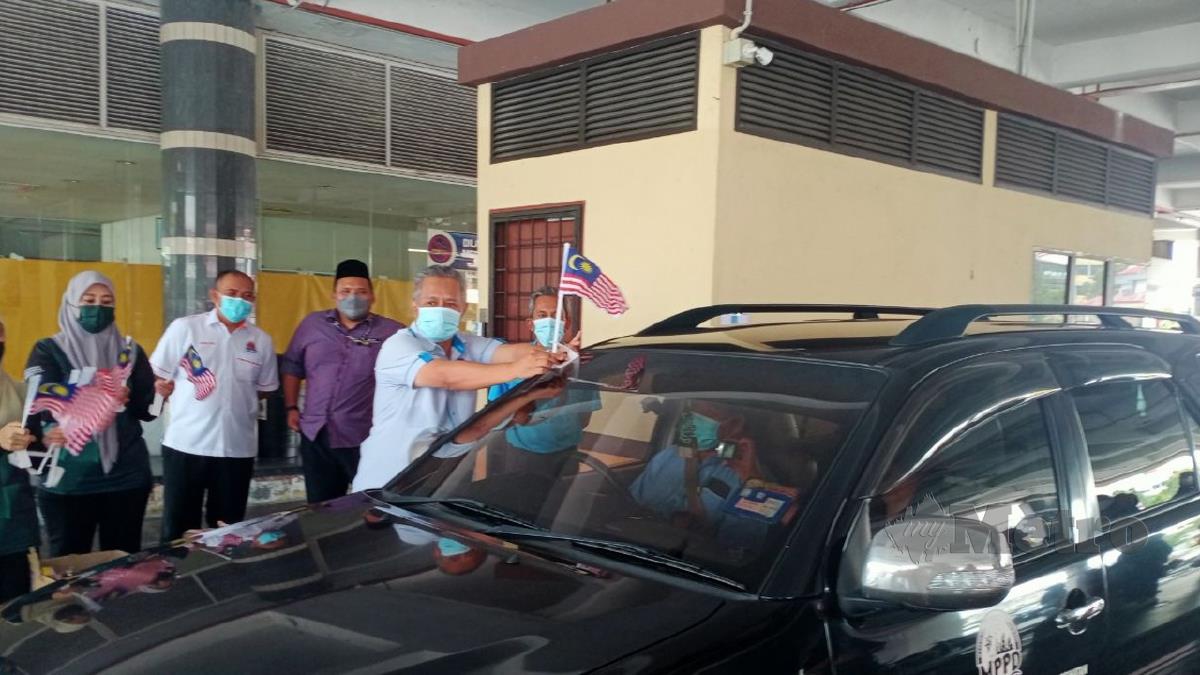 MOHD Zamri Mohd Esa sedang melekatkan bendera kepada kenderaan MPPD di Terminal Bas Port Dickson. FOTO Mohd Khidir Zakaria